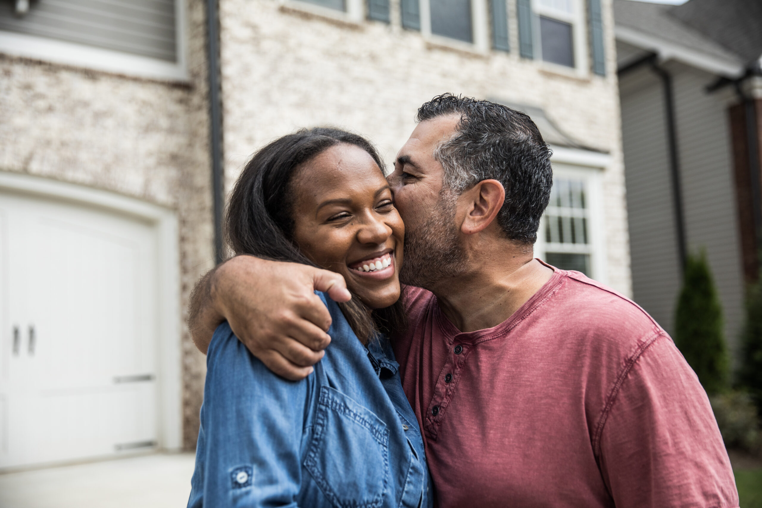 Portrait of couple out front of new home